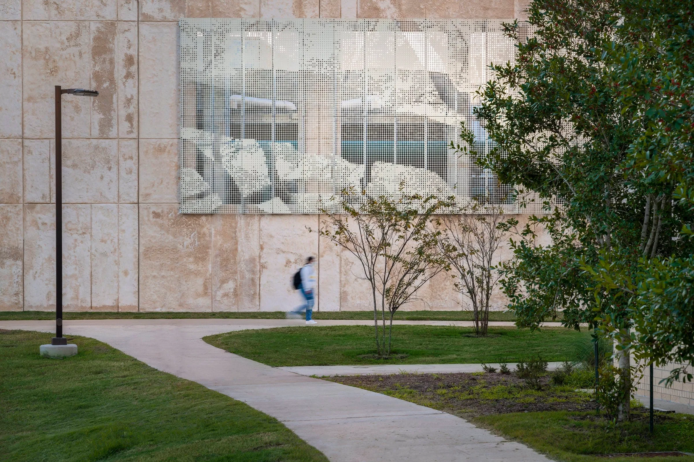 A student walking past the screen on a curving path
