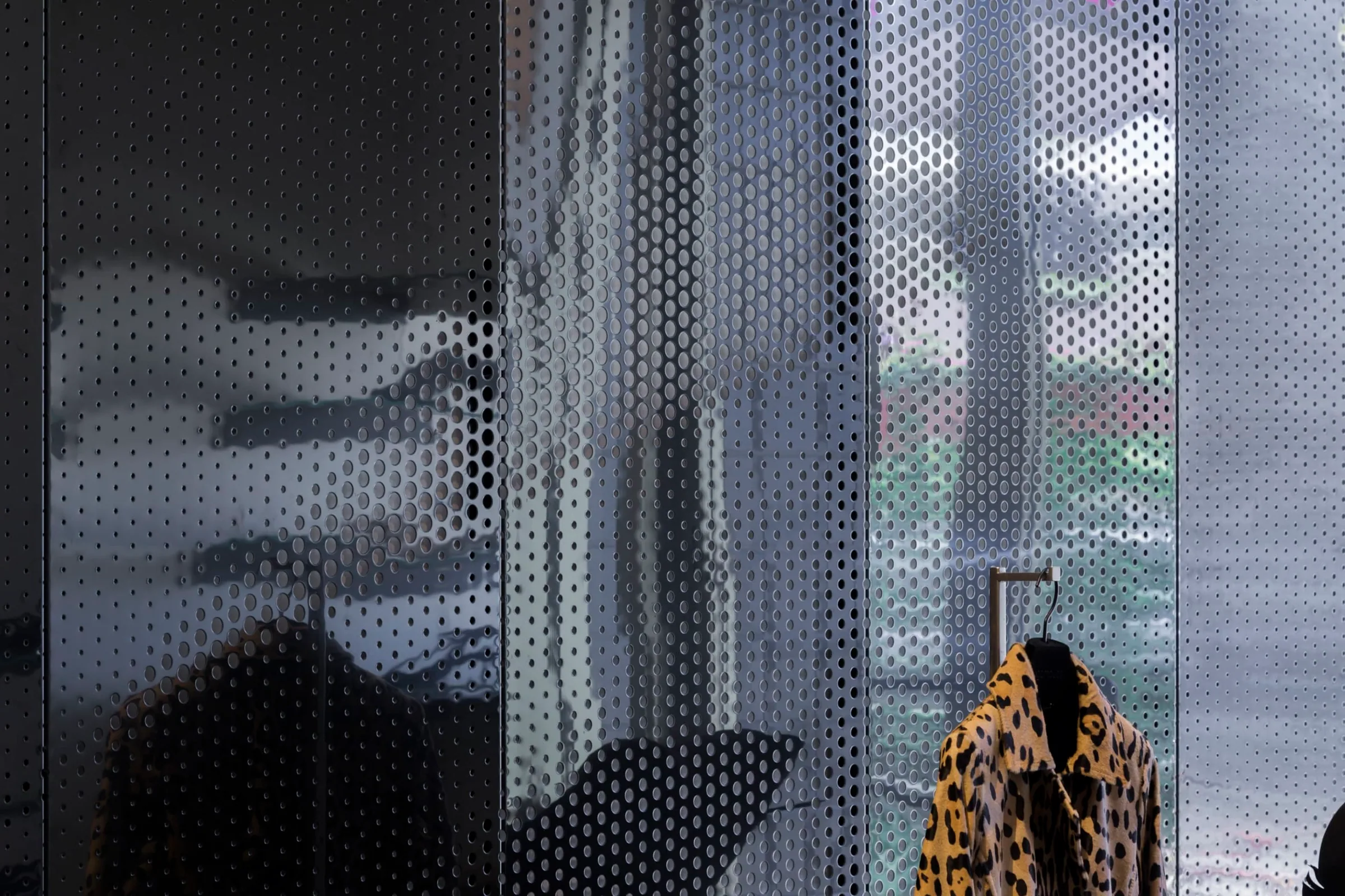 Perforated black steel panels beside a mannequin