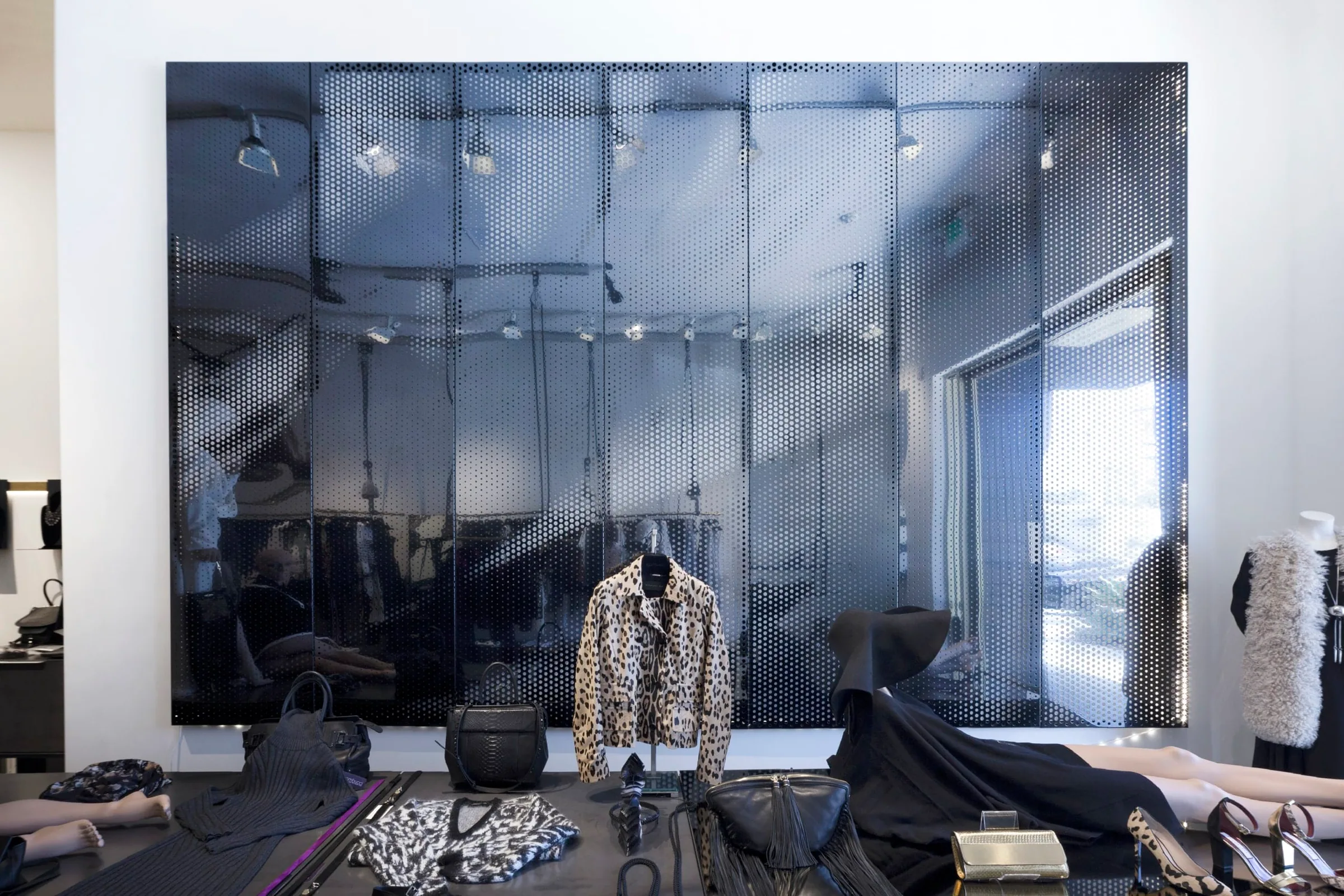 The black steel wall reflecting the shop’s light