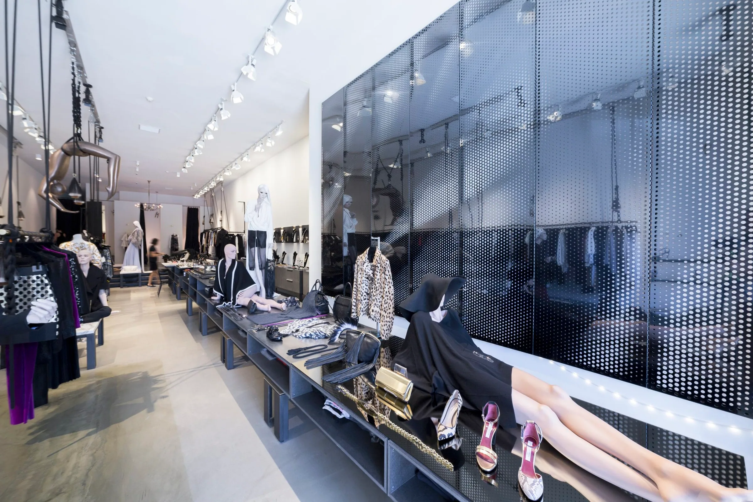 Display tables in front of the black perforated wall
