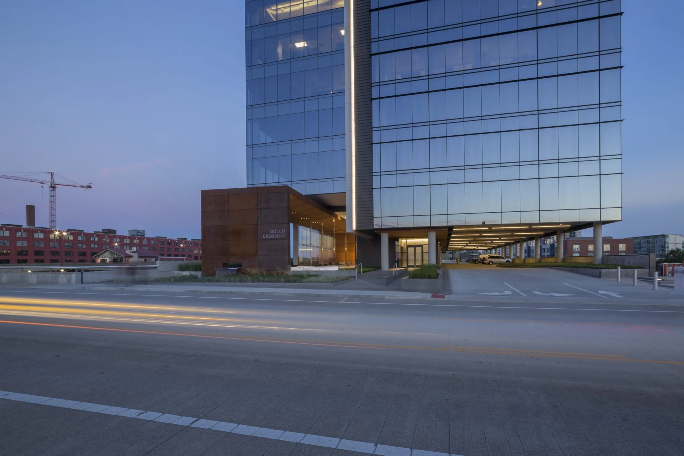 The tower and its steel canopy at dusk, traffic streaking by