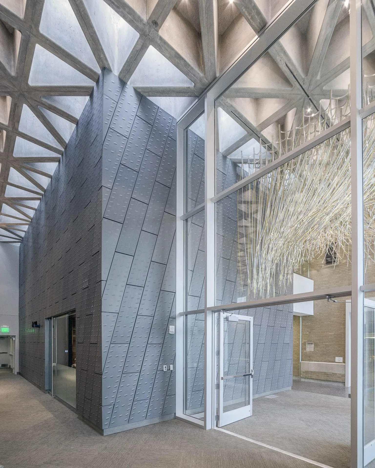 Steel branching columns in front of a zinc wall