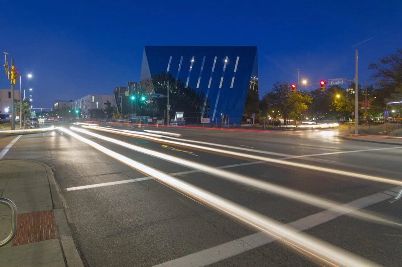 Light trails on the avenue below the lit museum at night