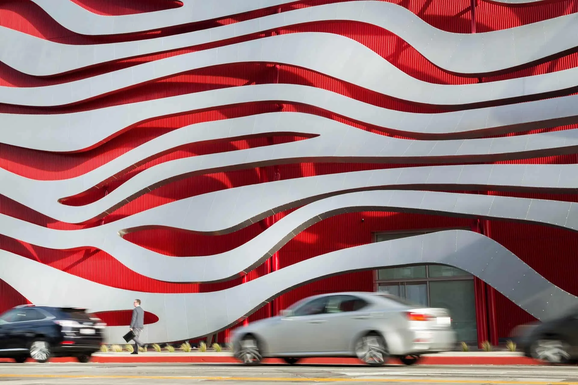 Steel ribbons sweeping over the façade above passing traffic