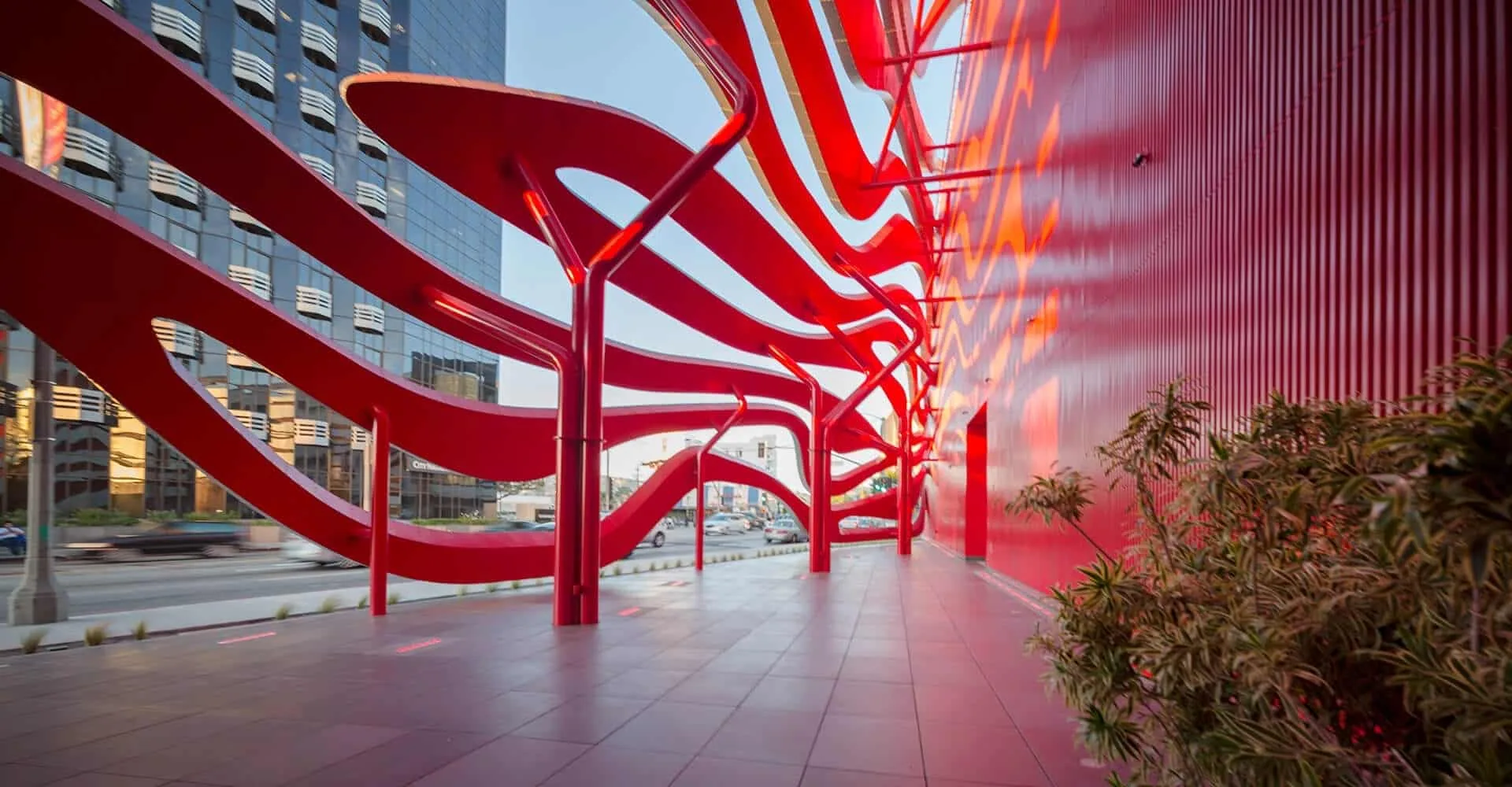 Red steel ribbons curling down to the sidewalk