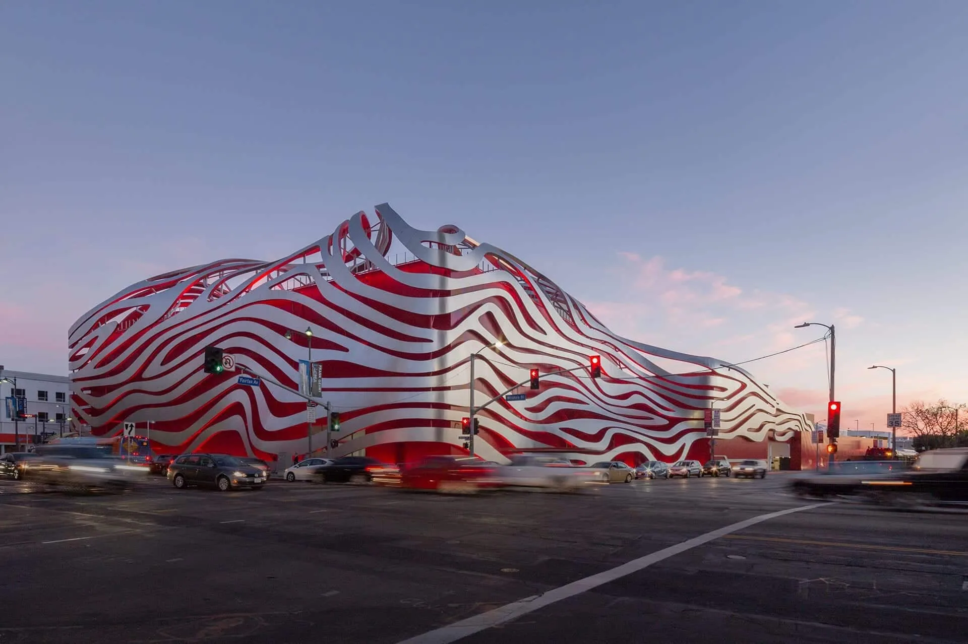The Petersen’s steel ribbons over its red façade at dusk