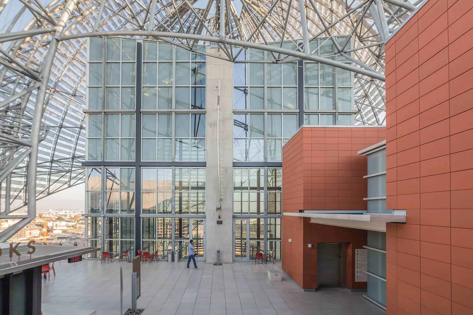 A terracotta-red volume inside the glass atrium under the dome