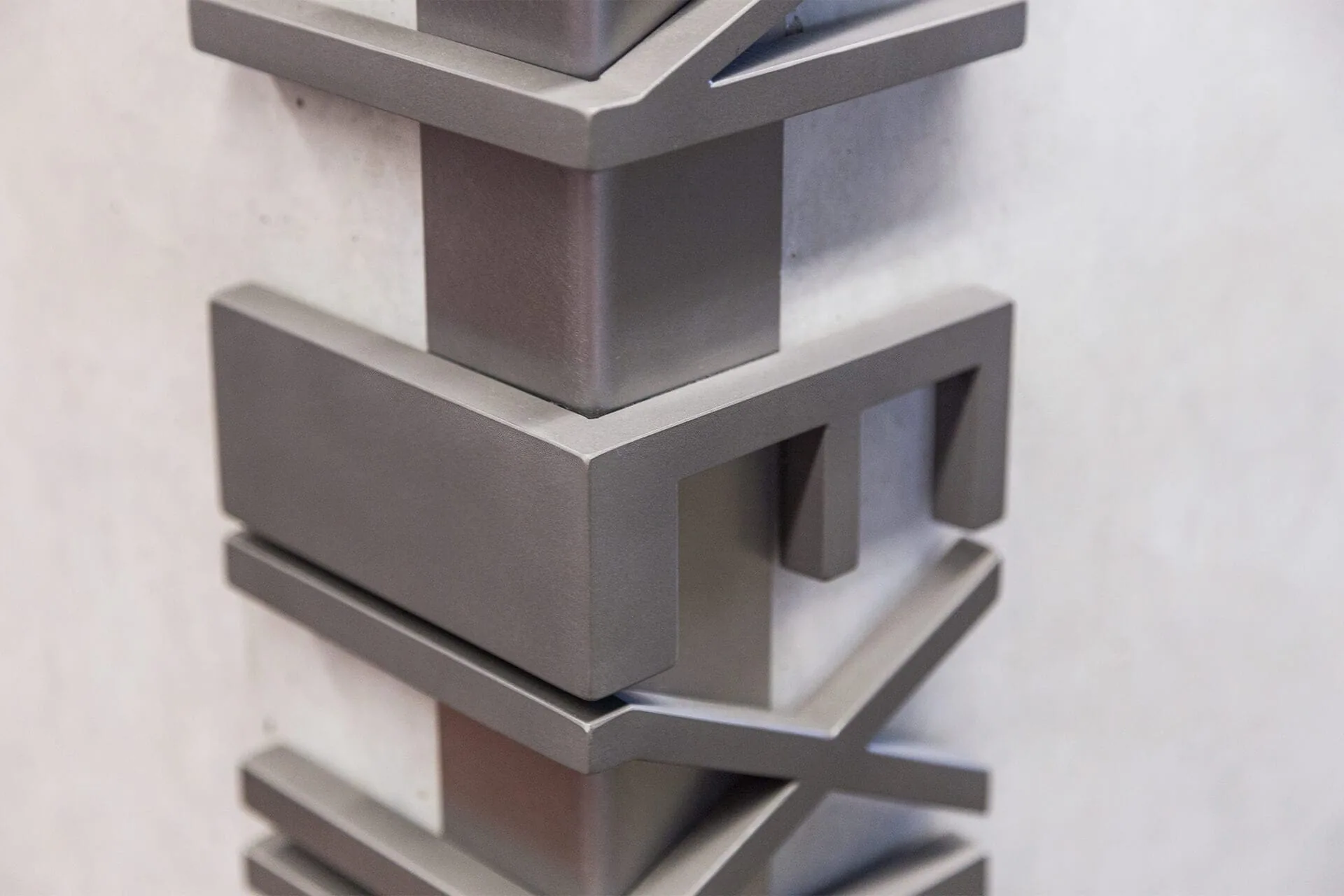 Stacked metal letters in a vertical sign