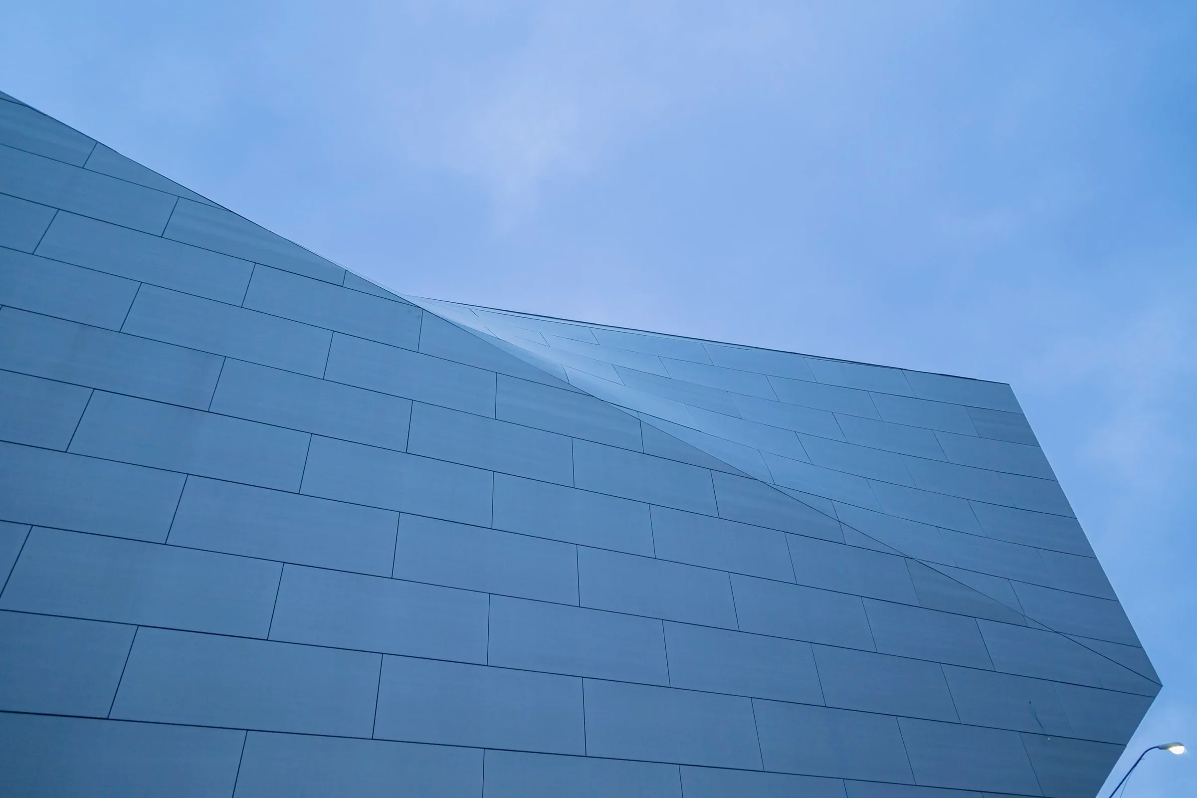 Zinc panels meeting at a sharp edge against the sky