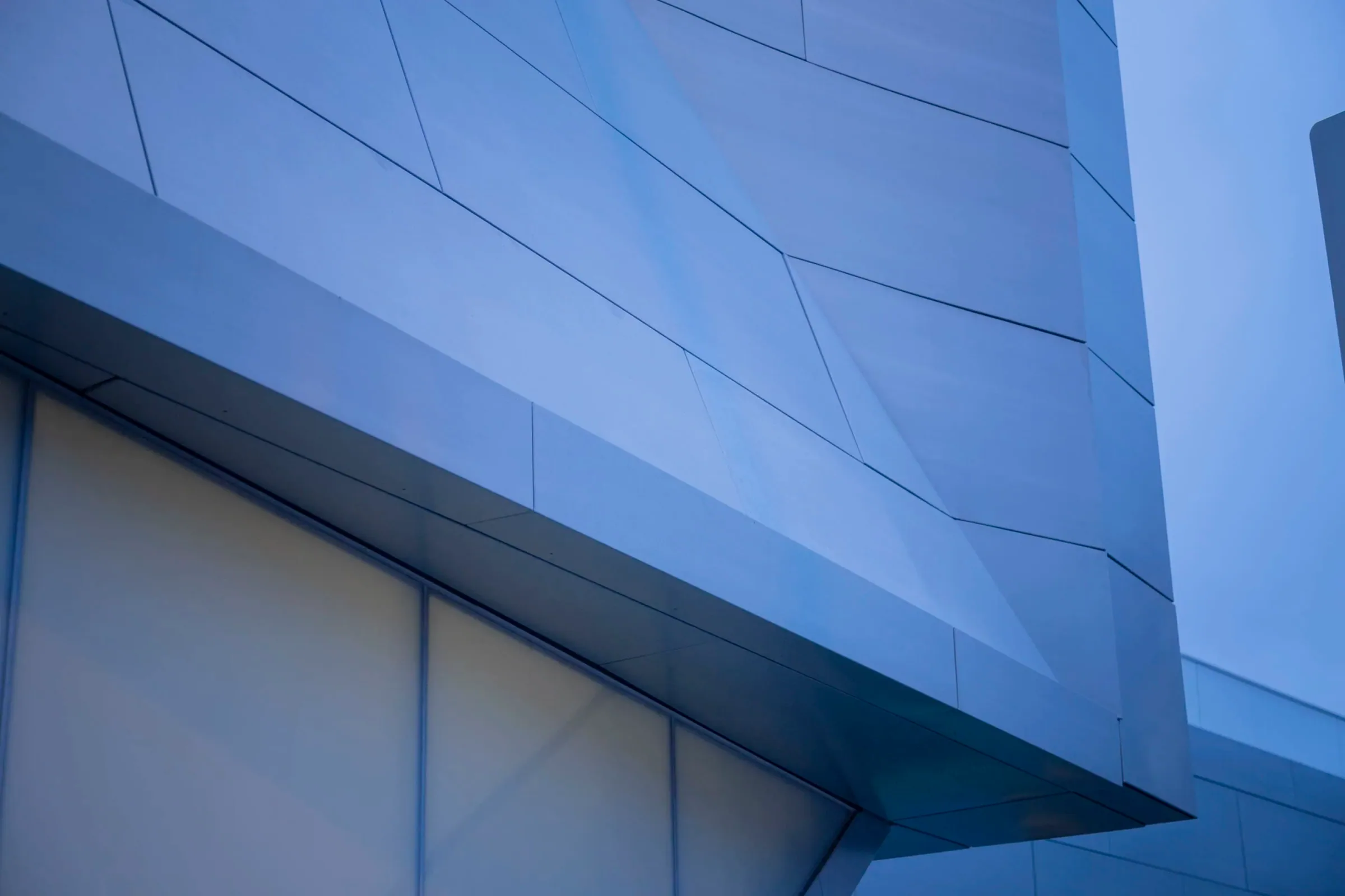 Zinc walls angling apart around a glass slot