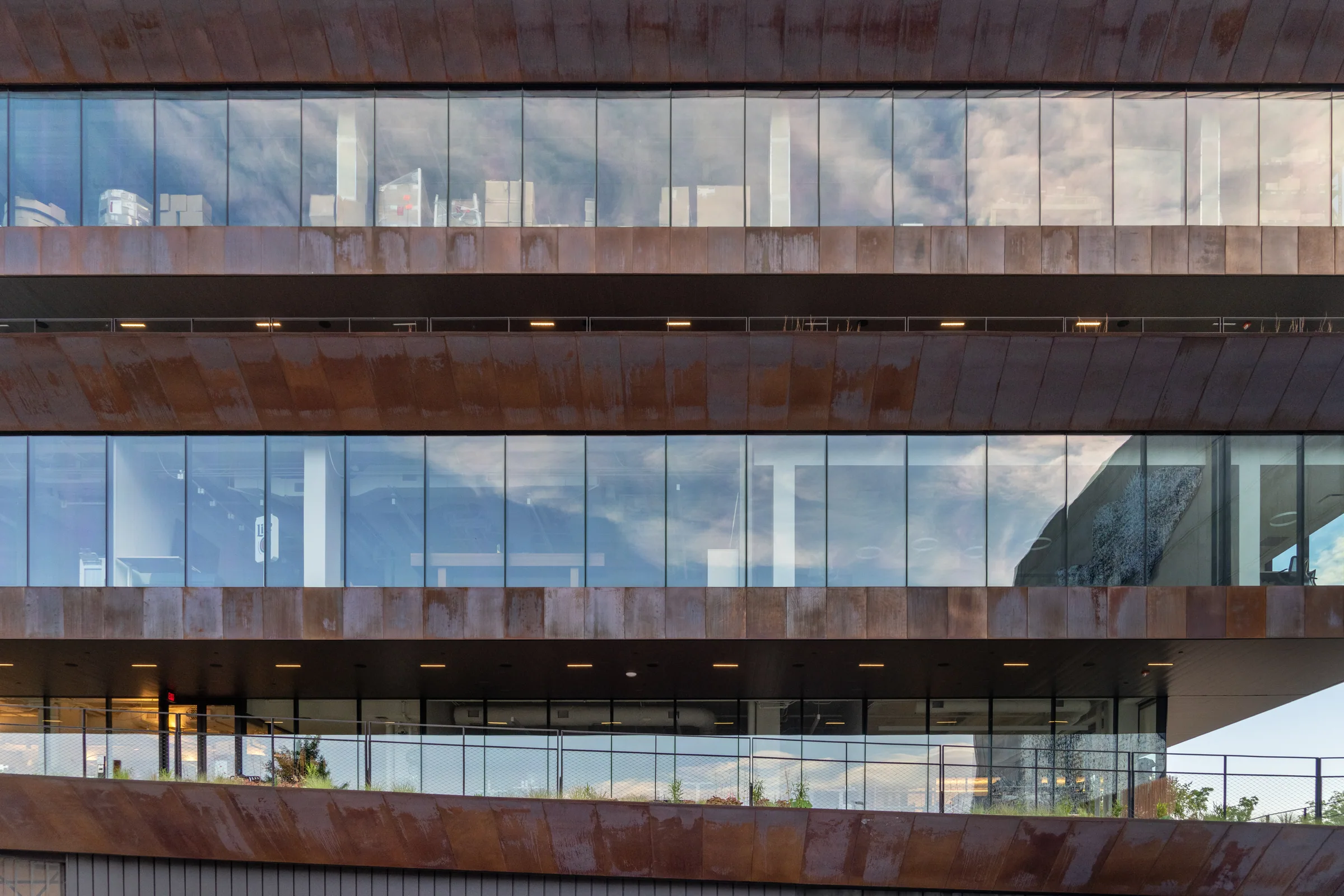 Copper bands and glass floors stacked across the façade
