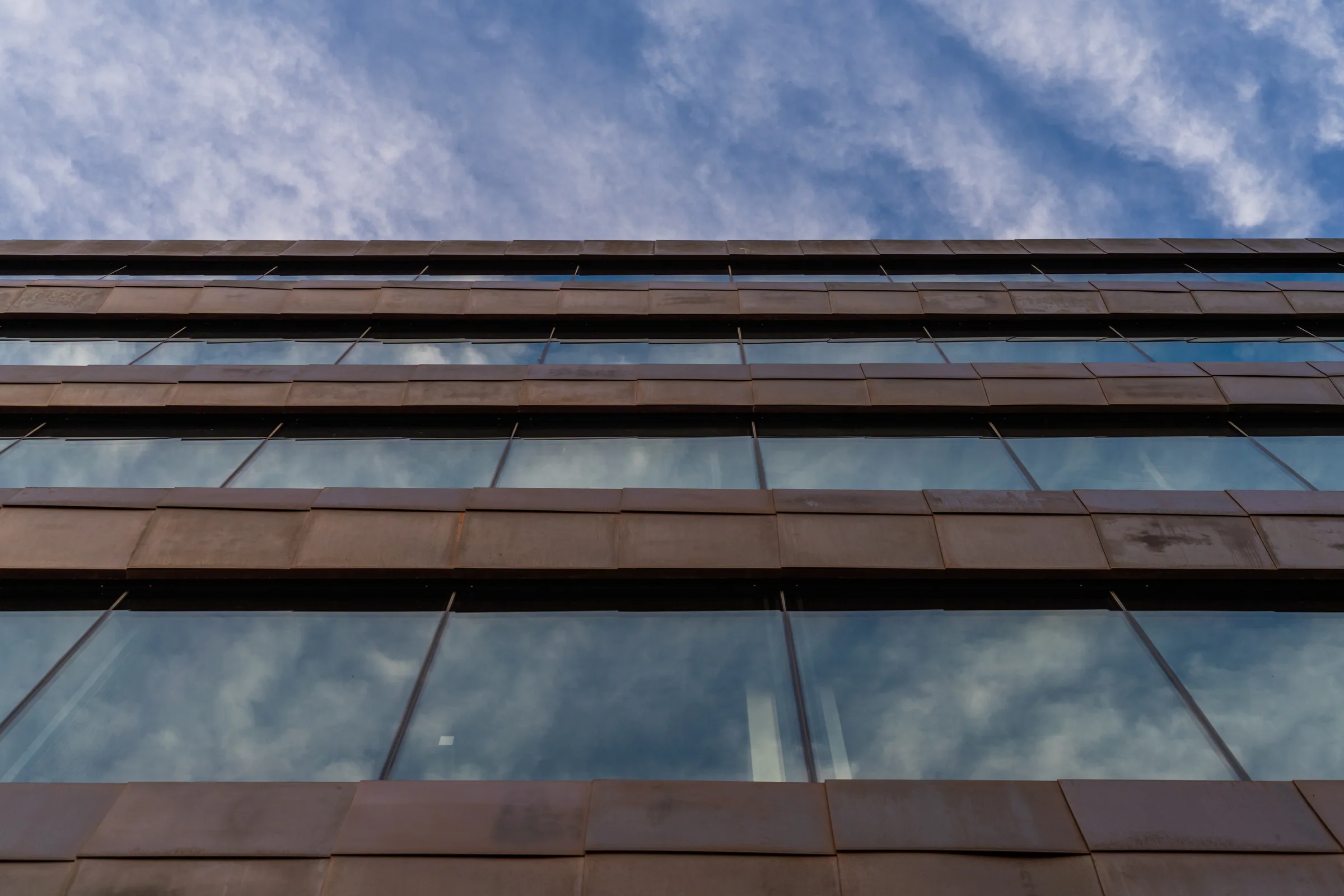 Looking up at copper fascias and reflected clouds