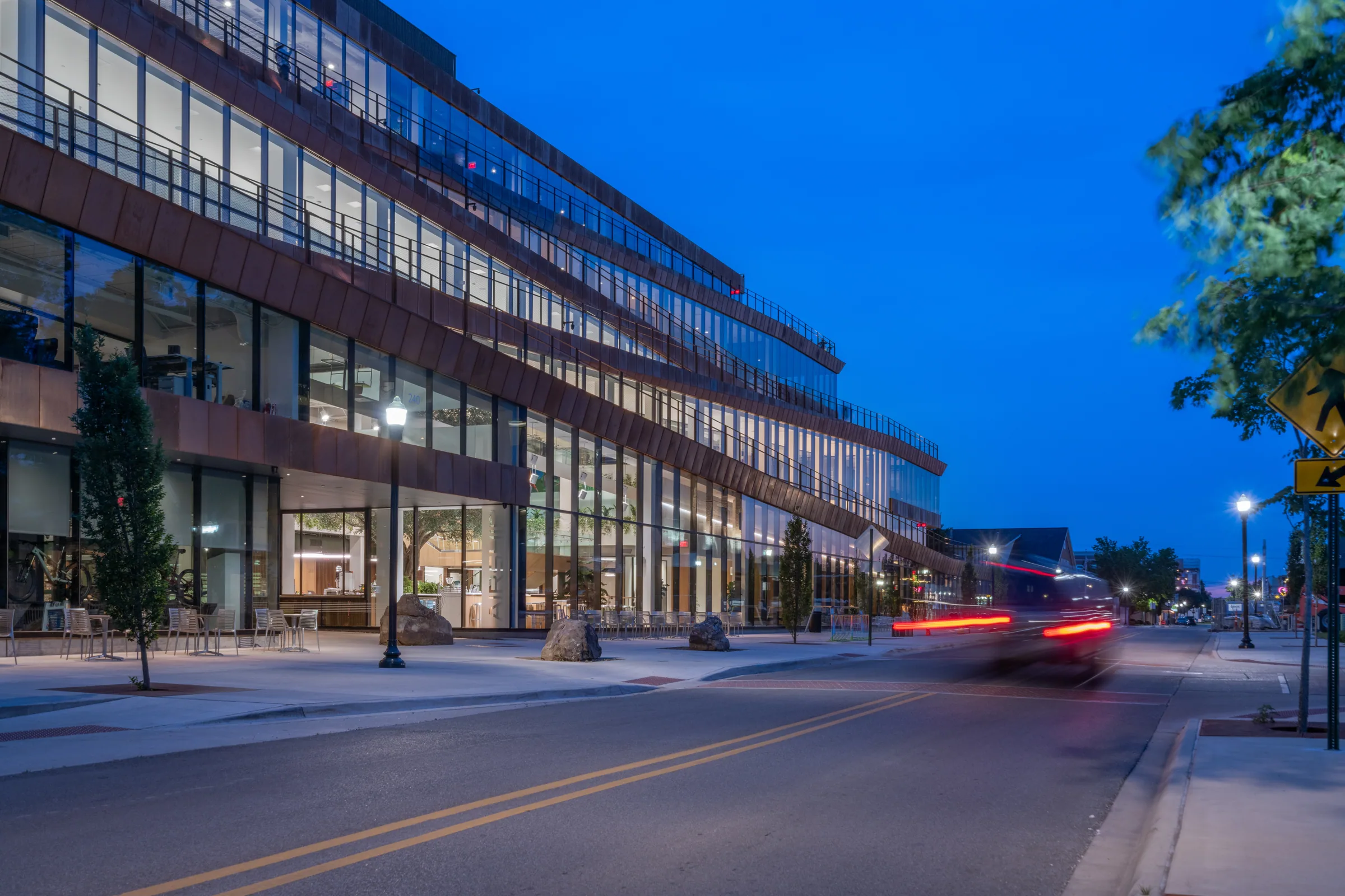 The building along the street at blue hour, car lights streaking past